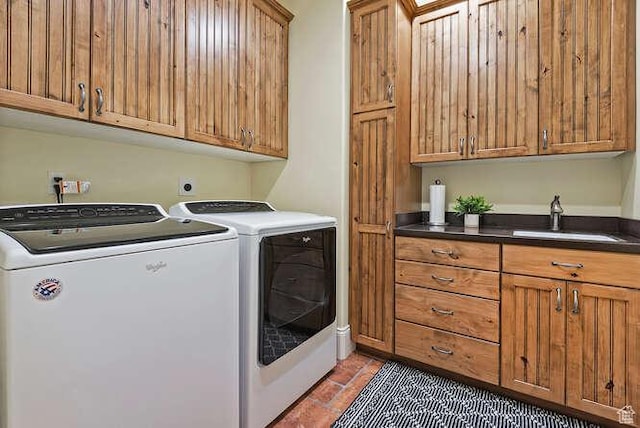 clothes washing area featuring separate washer and dryer, a sink, and cabinet space