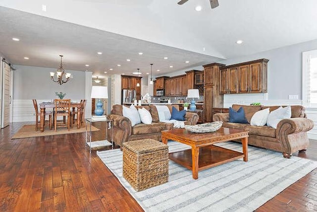 living room featuring ceiling fan with notable chandelier, recessed lighting, and dark wood finished floors