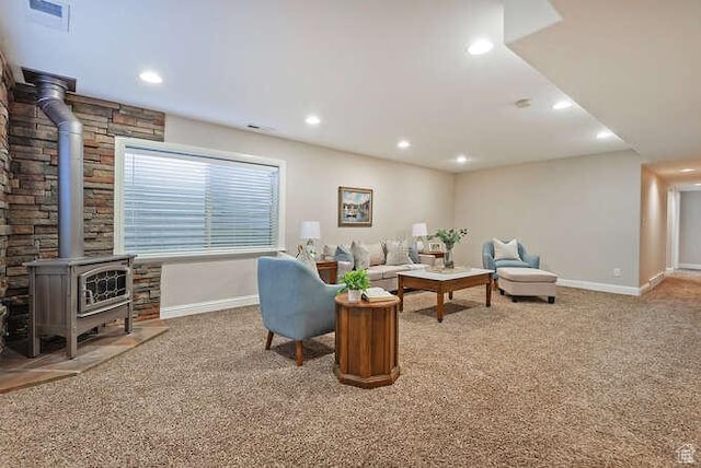 carpeted living room featuring a wood stove, baseboards, visible vents, and recessed lighting