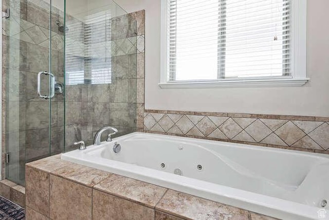bathroom with a stall shower and a jetted tub