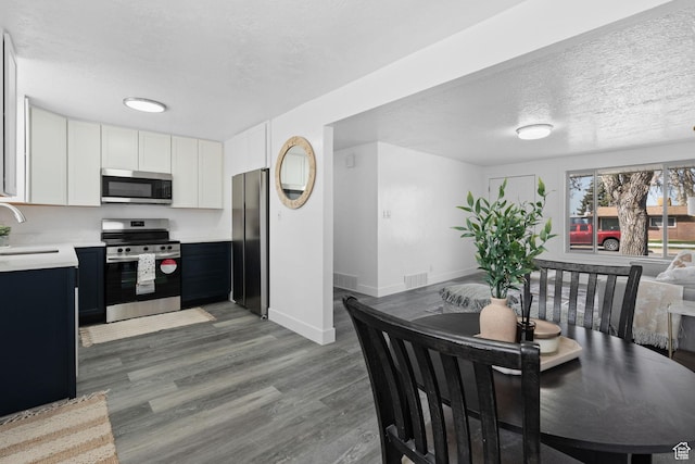 621 N 200 W, Clearfield, UT 84015 - dining area with visible vents, baseboards, wood finished floors, and a textured ceiling