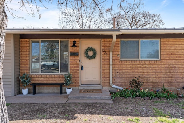 doorway to property with brick siding