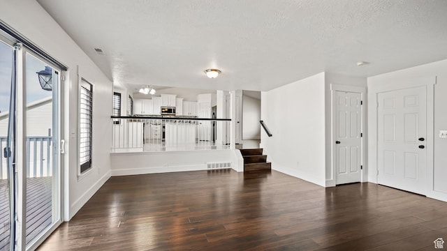 6258 W Graceland Way, West Jordan, UT 84081 - unfurnished living room featuring stairway, a textured ceiling, baseboards, and wood finished floors