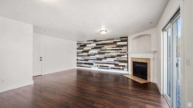 6258 W Graceland Way, West Jordan, UT 84081 - unfurnished living room featuring wood finished floors, an accent wall, a tiled fireplace, and baseboards