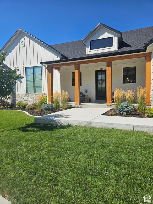 2345 E Cherry Ln, Layton, UT 84040 - modern farmhouse with board and batten siding, covered porch, stone siding, a front lawn, and a shingled roof