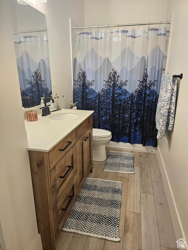 2345 E Cherry Ln, Layton, UT 84040 - bathroom with baseboards, a shower with curtain, toilet, vanity, and wood finished floors