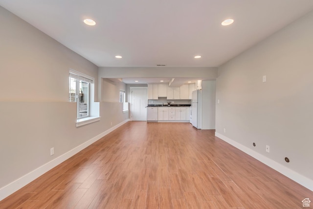11968 N Ithica Dr, Highland, UT 84003 - unfurnished living room with baseboards and light wood-type flooring