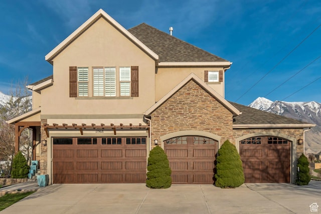 view of front of house with driveway, stucco siding, and stone siding