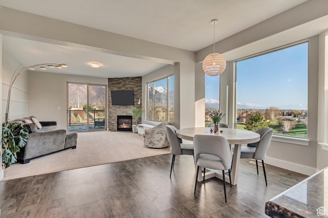 11968 N Ithica Dr, Highland, UT 84003 - dining space with baseboards, a notable chandelier, wood finished floors, and a fireplace