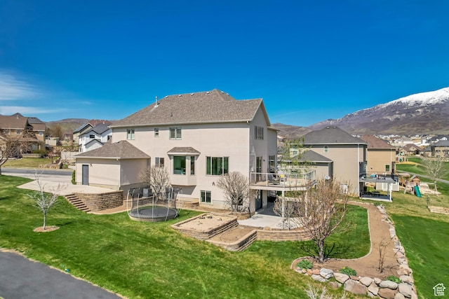 11968 N Ithica Dr, Highland, UT 84003 - rear view of property featuring a patio area, a trampoline, a lawn, stucco siding, and a residential view