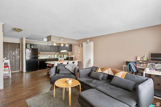 living room with dark wood-type flooring, visible vents, and a textured ceiling