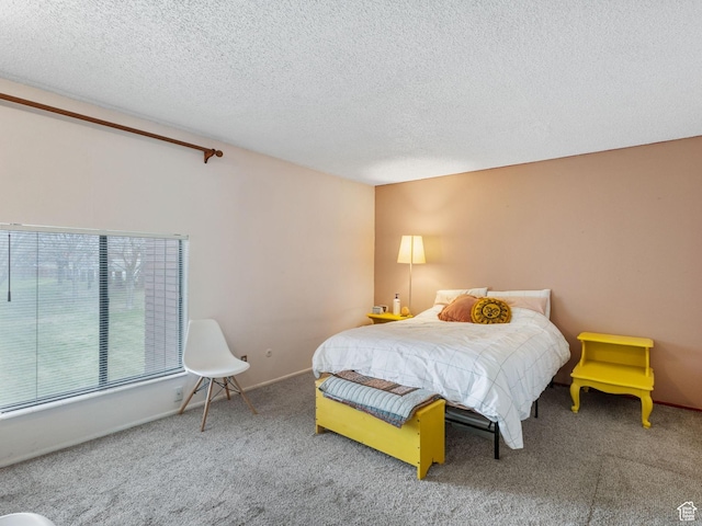 carpeted bedroom featuring a textured ceiling and baseboards