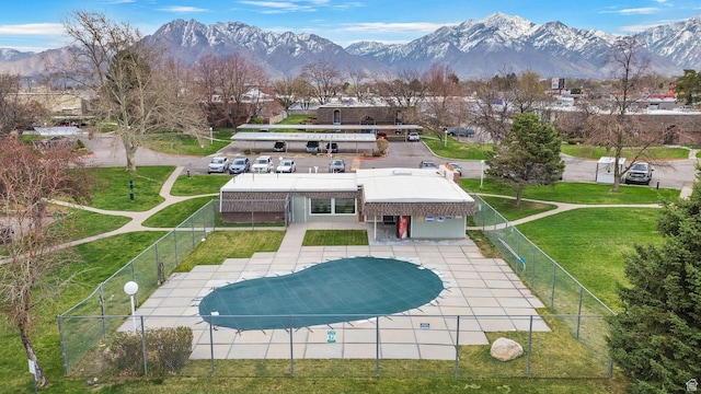 back of property with a yard, fence private yard, a patio area, a mountain view, and a fenced in pool