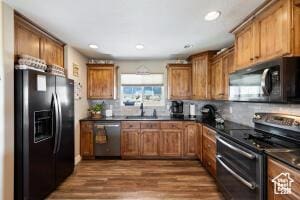 8836 W 3200 S, Cedar City, UT 84720 - kitchen featuring dark wood-style flooring, dark countertops, brown cabinets, black appliances, and backsplash