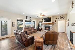 8836 W 3200 S, Cedar City, UT 84720 - living area featuring baseboards, a stone fireplace, a ceiling fan, and wood finished floors