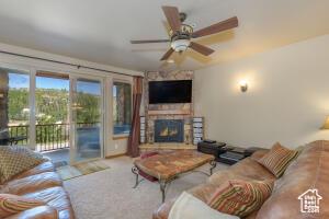 565 S Vasels Rd E Unit 6G, Brian Head, UT 84719 - living area with carpet flooring, a stone fireplace, and a ceiling fan