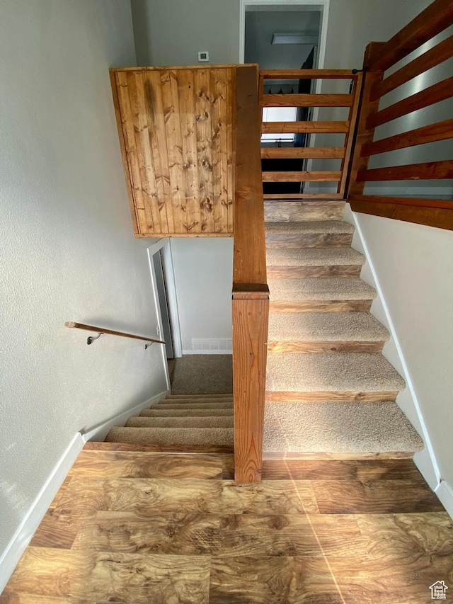 stairway with baseboards and visible vents