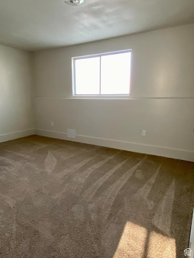 empty room featuring baseboards and carpet floors