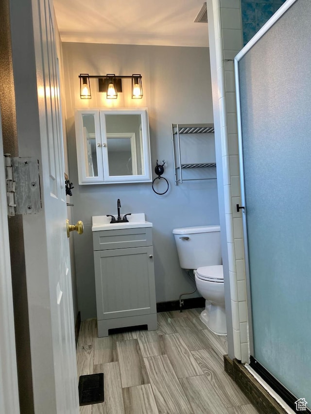 full bathroom featuring visible vents, baseboards, toilet, a shower stall, and vanity