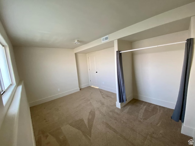 unfurnished bedroom featuring carpet, visible vents, and baseboards