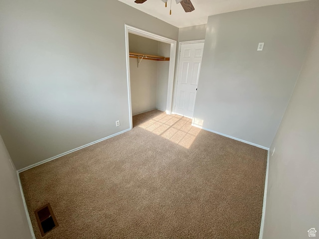 unfurnished bedroom with light carpet, a closet, baseboards, and ceiling fan