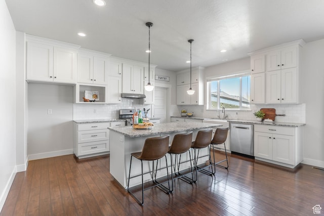 81 E 600 N, Mapleton, UT 84664 - kitchen with white cabinets, stainless steel appliances, a center island, baseboards, and under cabinet range hood