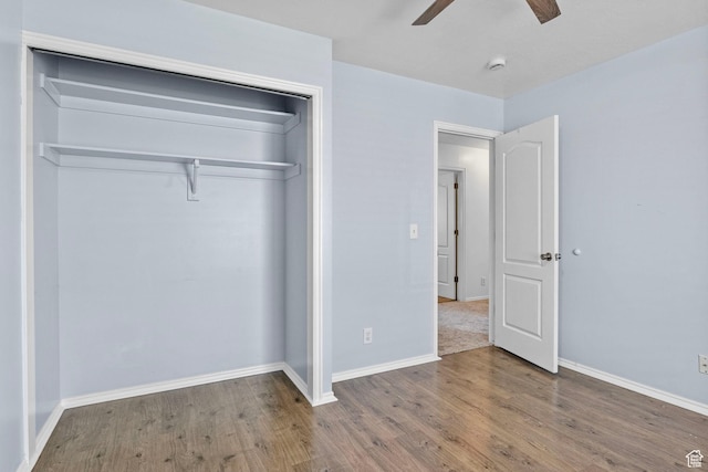 unfurnished bedroom with a closet, a ceiling fan, baseboards, and wood finished floors