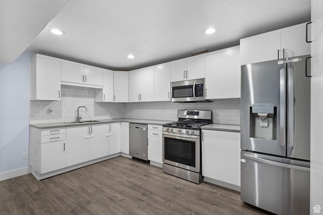 kitchen featuring a sink, stainless steel appliances, dark wood-style floors, and white cabinetry