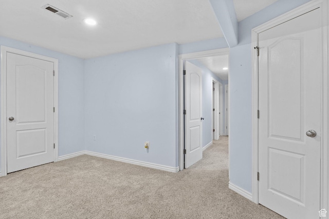 empty room with baseboards, light carpet, recessed lighting, and visible vents