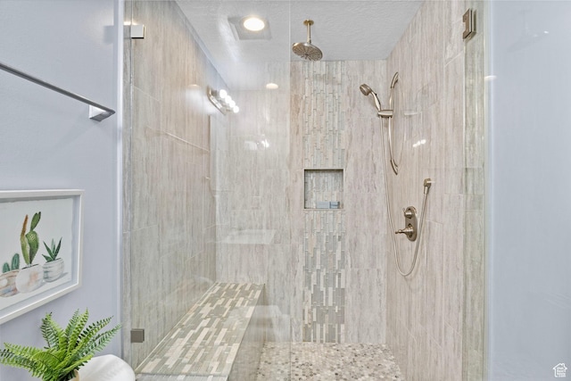 bathroom featuring a textured ceiling and a shower stall