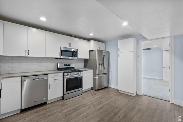 kitchen with light countertops, appliances with stainless steel finishes, baseboards, and wood finished floors