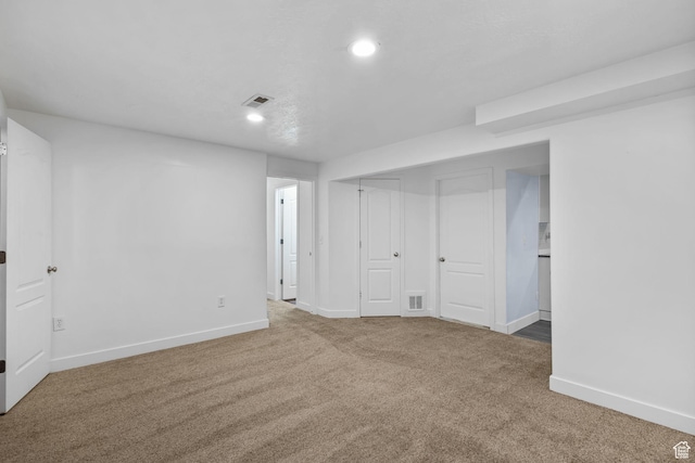 below grade area with baseboards, carpet flooring, recessed lighting, and visible vents