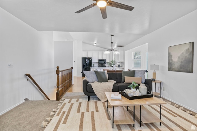 living room with baseboards, ceiling fan, and lofted ceiling