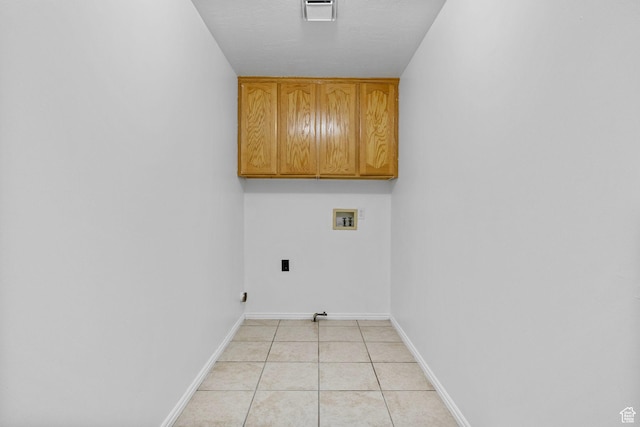 laundry area featuring washer hookup, visible vents, cabinet space, baseboards, and light tile patterned flooring