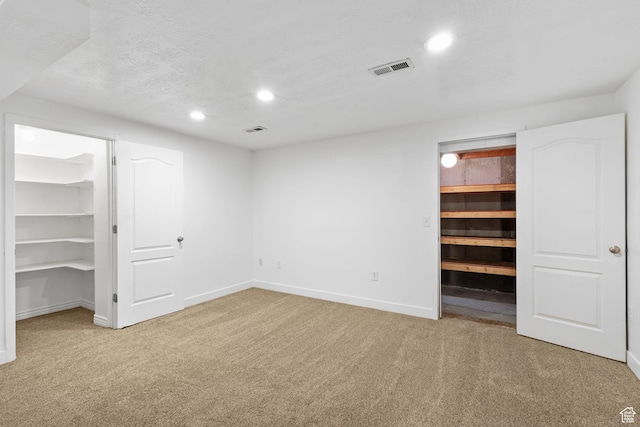 unfurnished bedroom featuring a walk in closet, recessed lighting, and carpet floors