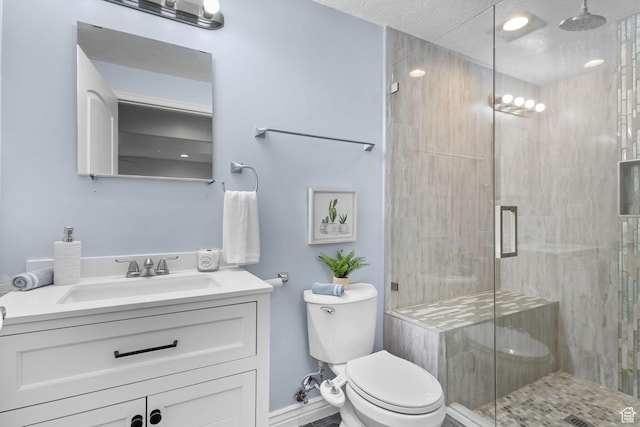 bathroom featuring vanity, a stall shower, and toilet