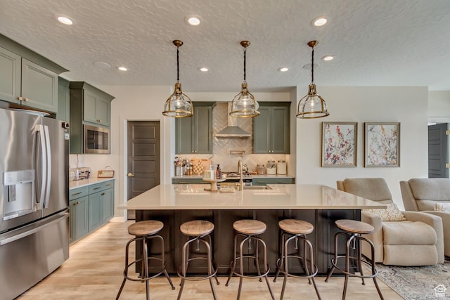 419 W 850 N, Farmington, UT 84025 - kitchen with green cabinets, wall chimney range hood, appliances with stainless steel finishes, a sink, and open floor plan