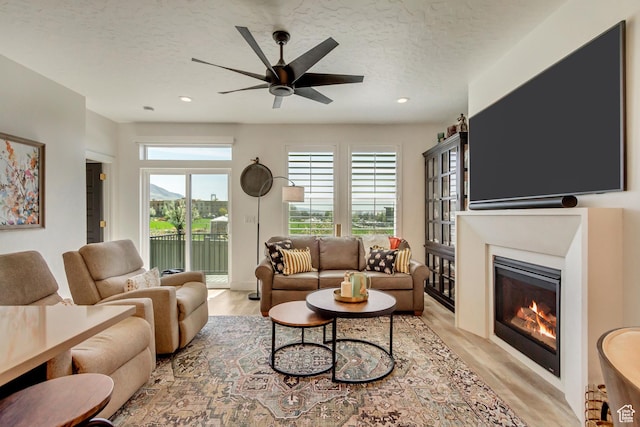 419 W 850 N, Farmington, UT 84025 - living area with ceiling fan, light wood-type flooring, a glass covered fireplace, and a textured ceiling