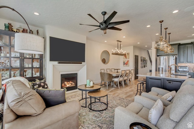 419 W 850 N, Farmington, UT 84025 - living room featuring a glass covered fireplace, recessed lighting, a textured ceiling, a ceiling fan, and light wood-style floors