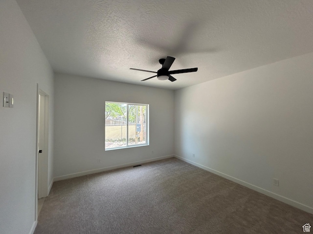 empty room with ceiling fan, light carpet, baseboards, and a textured ceiling