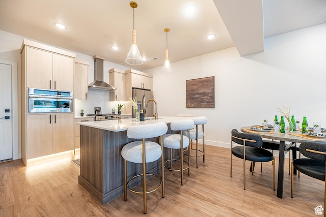 4342 W 5430 S Unit B, Roy, UT 84067 - kitchen with wall chimney range hood, appliances with stainless steel finishes, light wood-style floors, an island with sink, and backsplash