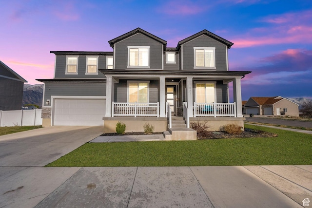 traditional home with driveway, a porch, a garage, a yard, and fence