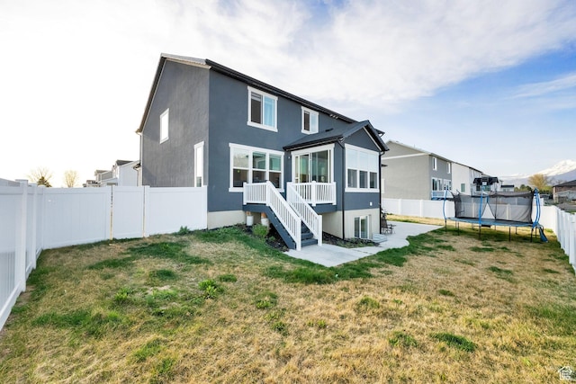 977 S 1480 W, Provo, UT 84601 - rear view of property with a yard, a fenced backyard, stucco siding, a patio, and a trampoline