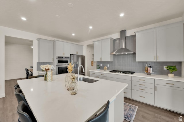 977 S 1480 W, Provo, UT 84601 - kitchen featuring wall chimney exhaust hood, tasteful backsplash, wood finished floors, a sink, and stainless steel appliances