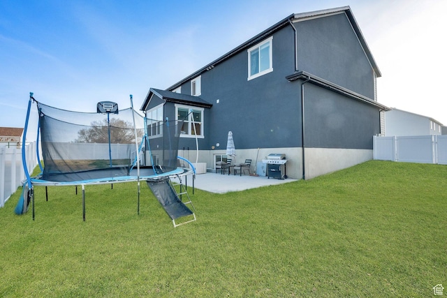 977 S 1480 W, Provo, UT 84601 - rear view of property featuring a yard, a patio area, a trampoline, a fenced backyard, and stucco siding