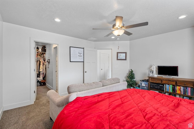 bedroom featuring carpet floors, a spacious closet, recessed lighting, and a textured ceiling