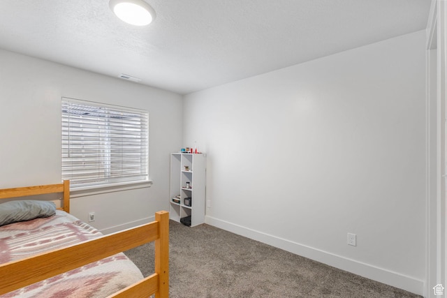 bedroom featuring visible vents, baseboards, a textured ceiling, and carpet floors