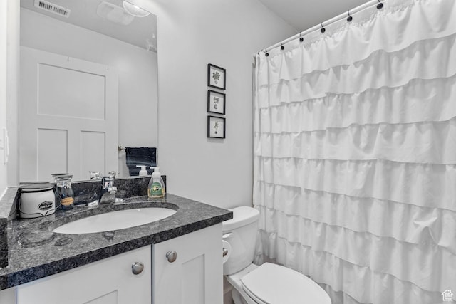 bathroom with visible vents, toilet, vanity, and a shower with curtain