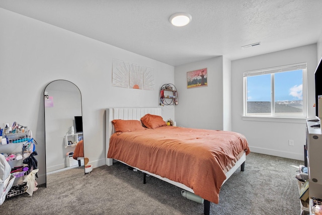 bedroom with a textured ceiling, baseboards, and carpet floors