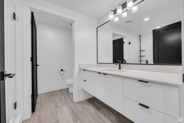 933 S Washington St Unit 107, Salt Lake City, UT 84101 - full bathroom featuring vanity, visible vents, baseboards, and toilet